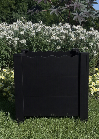 A black cedar flower planter box with a scalloped top edge.  Handcrafted with a unique design and looks great on a porch or back deck.