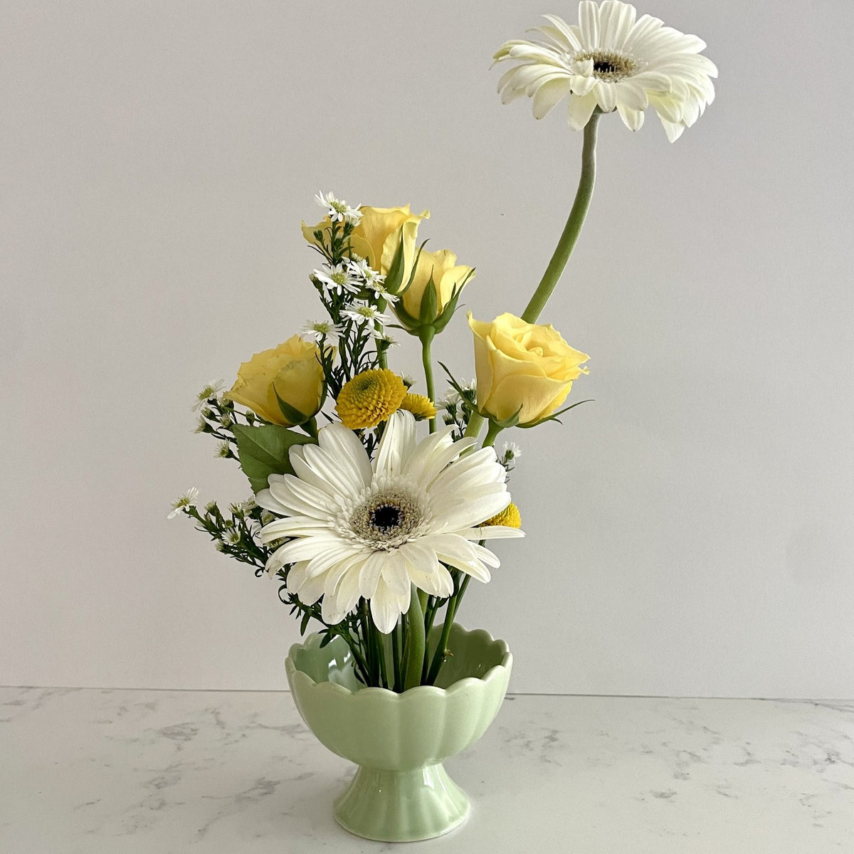 A pale green ceramic vase with a built in flower frog pin allowing for interesting stem placement.  Looks great on kitchen counters, bathrooms, bedrooms.   